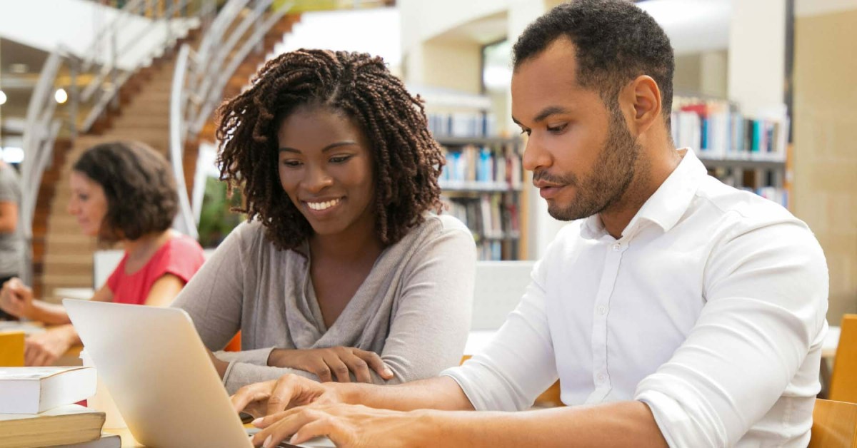 Photo of two people collaborating at a laptop