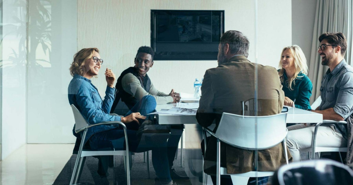 Photo of five people meeting around a table