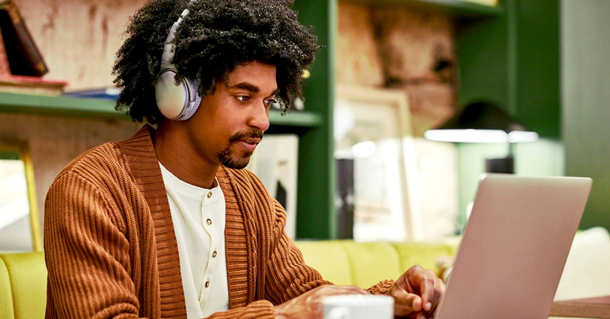 A man working on his laptop with headphones on