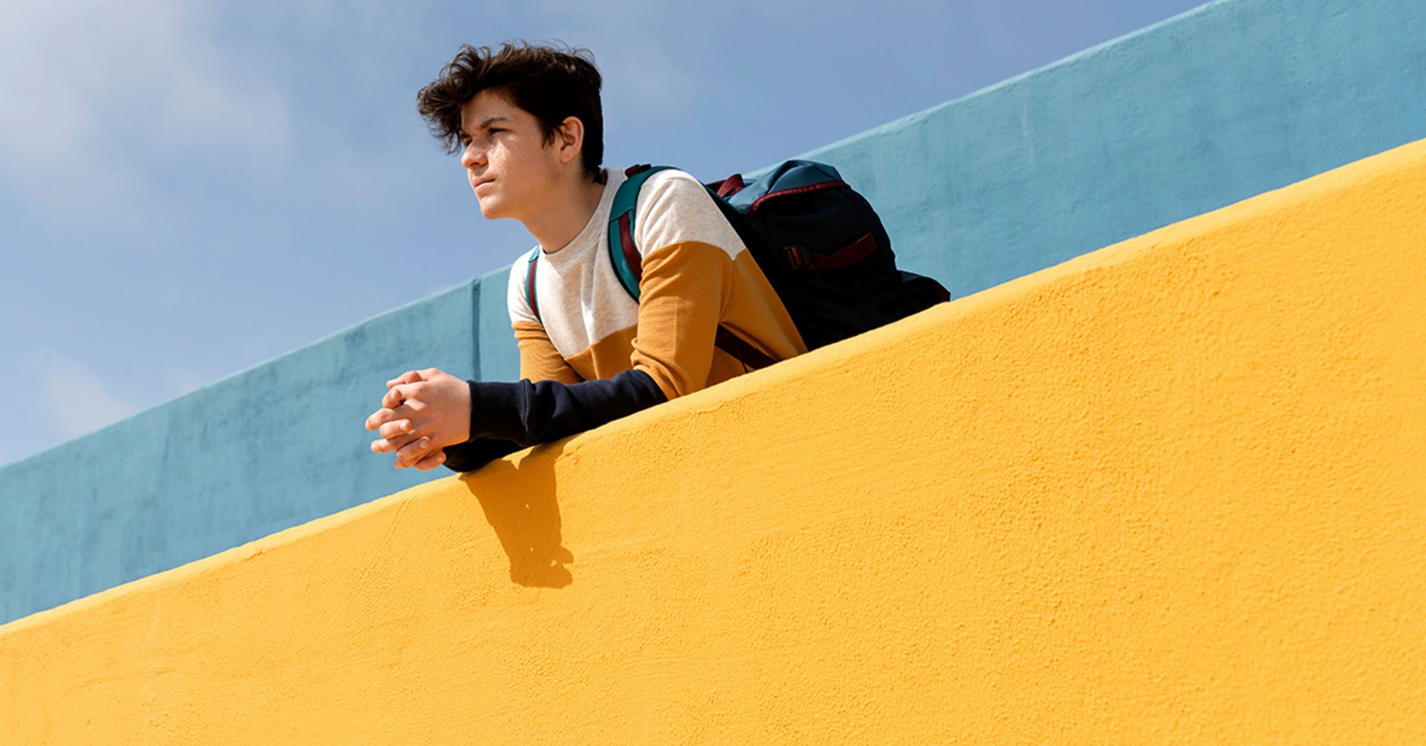 Photo of a student leaning over a retaining wall