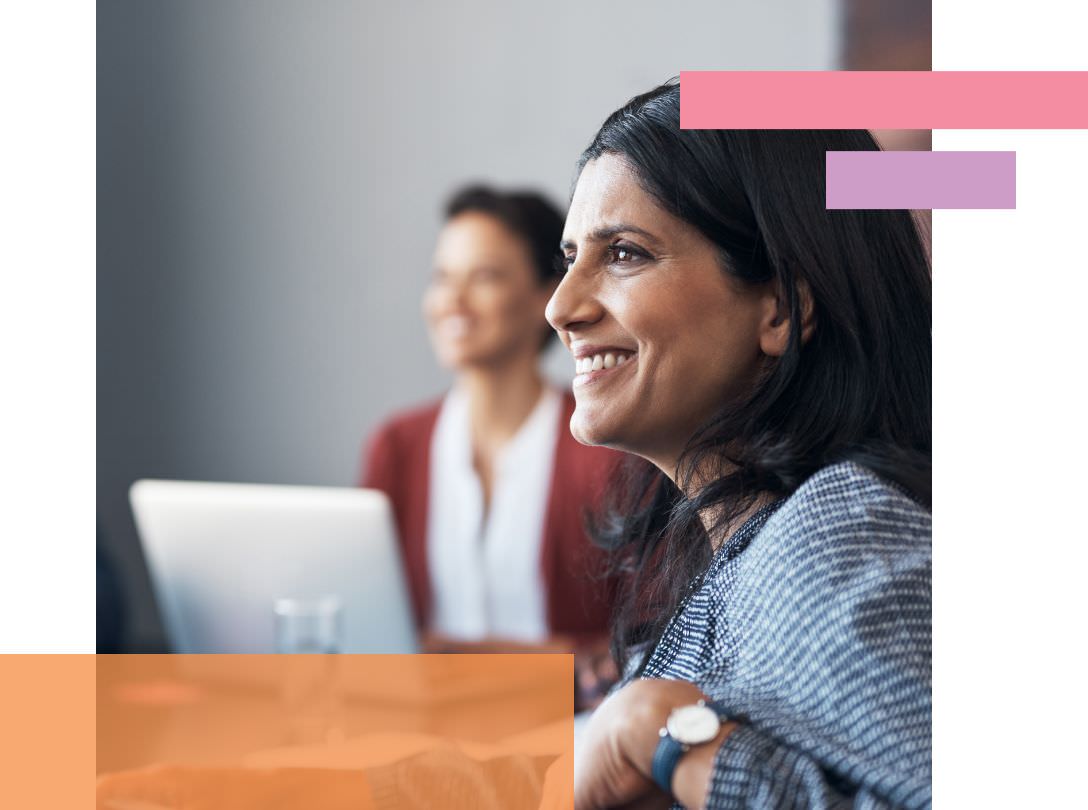 Two women smiling in a work meeting